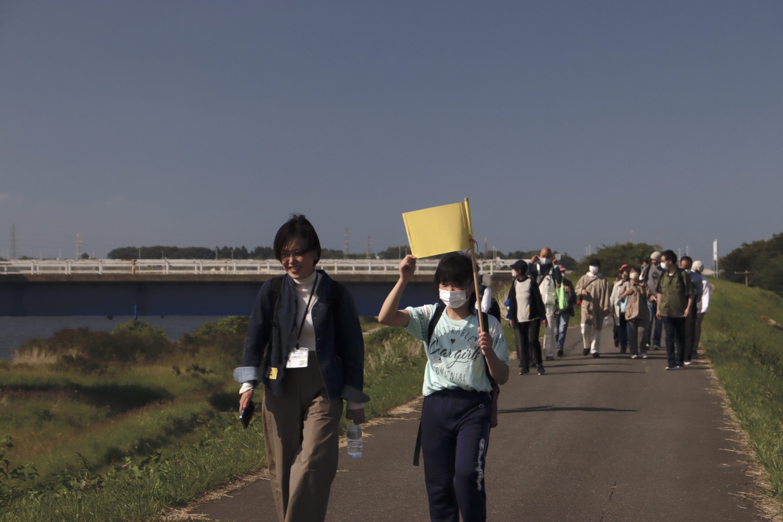 馬淵川沿いの堤防を歩く参加者たち